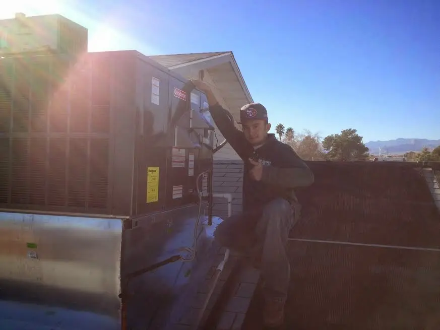 HVAC technician performing AC Tune-Up on a rooftop unit in Fort Irwin